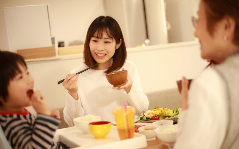 Family eating a relaxed dinner together helps children digest their food. It's a critical part of a healthy feeding schedule for your child.